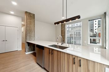 A modern kitchen with wooden cabinets and a large island. at Ion Town Center, Shoreline, WA